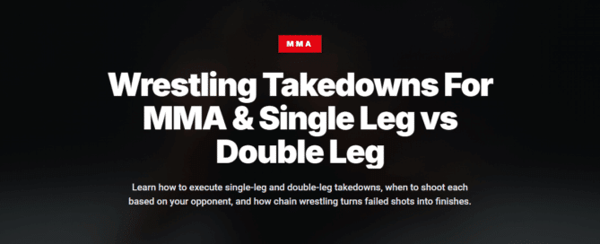 MMA wrestler executing double leg takedown on gym mats with proper form