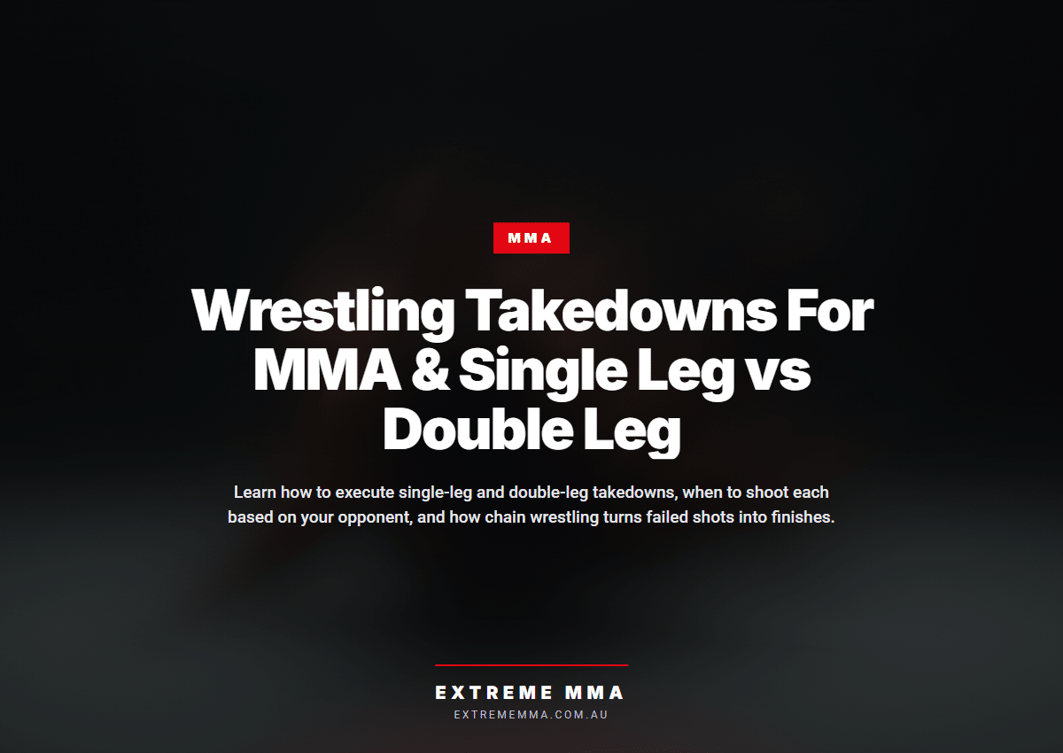 MMA wrestler executing double leg takedown on gym mats with proper form